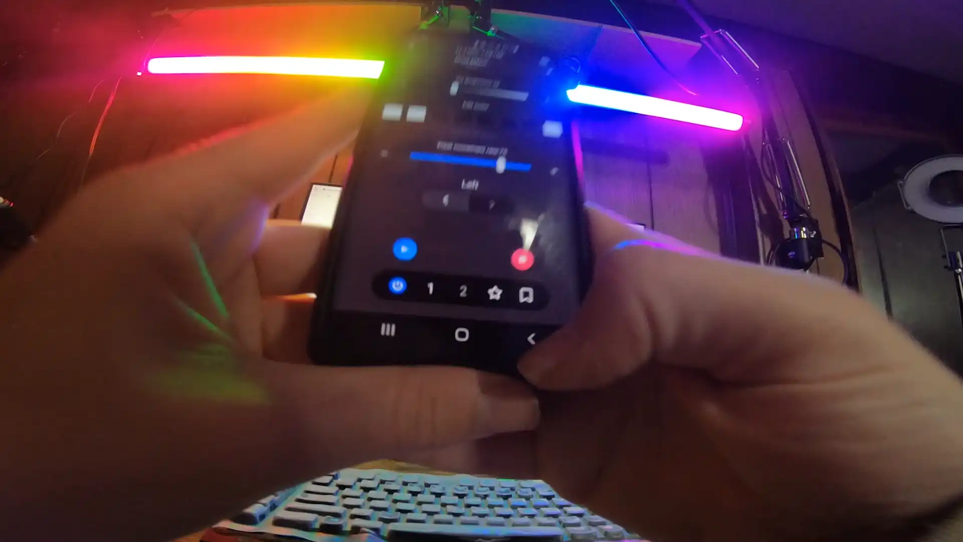 Hand holding smartphone with colorful LED light control app.